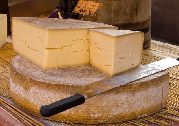 a wheel of cut gruyere cheese