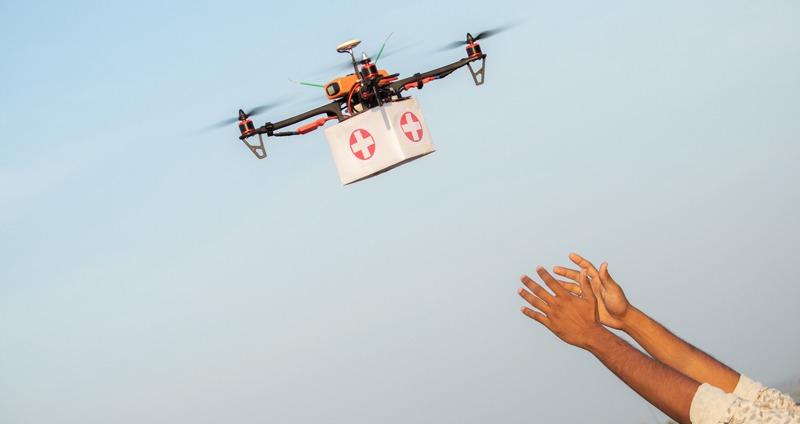 Drone Delivering First Aid Box or medicine to costumer hand during covid-19 or coronavirus lockdown - Advancing Medical Industry Logistics for Drug Transport concept.