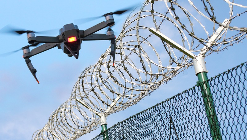Drone monitoring barbed wire fence on state border or restricted area.