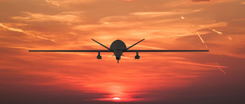 Silhouette of spy drone flying over the sea (UAV) and on background beautiful view
