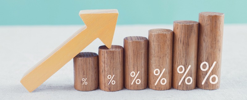 Wooden blocks with percentage sign and arrow up, financial growth, interest rate and mortgage rate increase