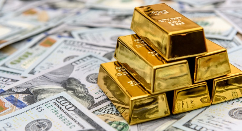 Gold bullion on american dollar banknotes close up