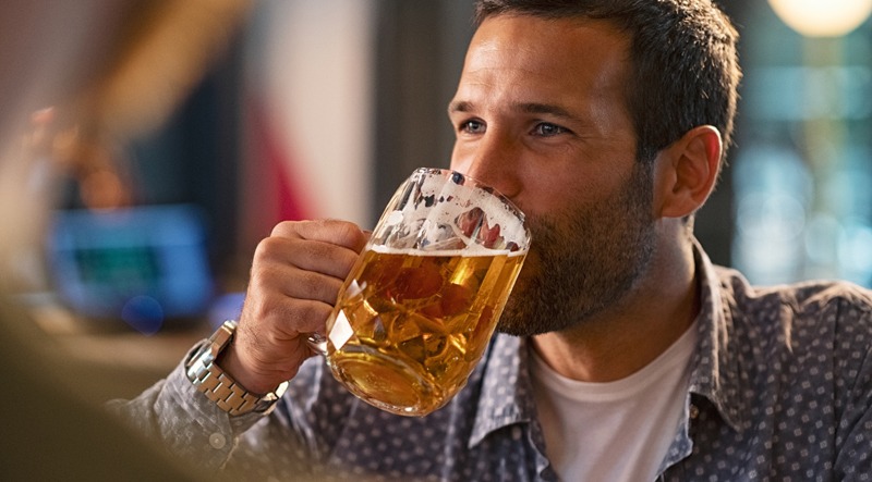 Man drinking a pint of draft beer