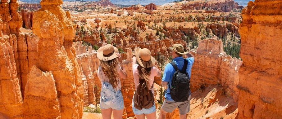 three-tourists-looking-at-the-Grand-Canyon
