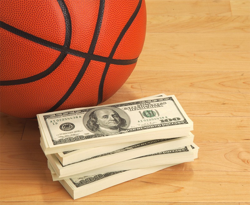 A basketball-and one hundred bills on a wooden court