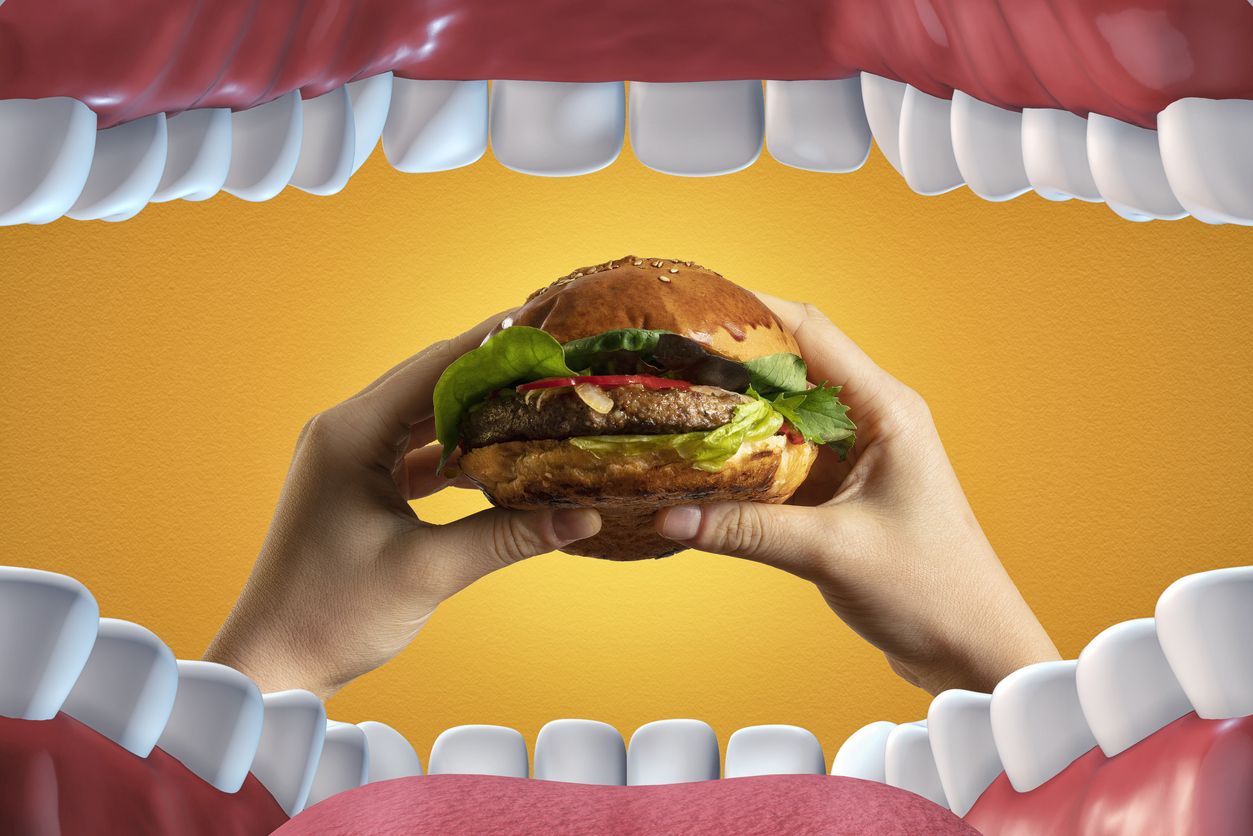 Eating large hamburger sandwich from major fast food restaurant