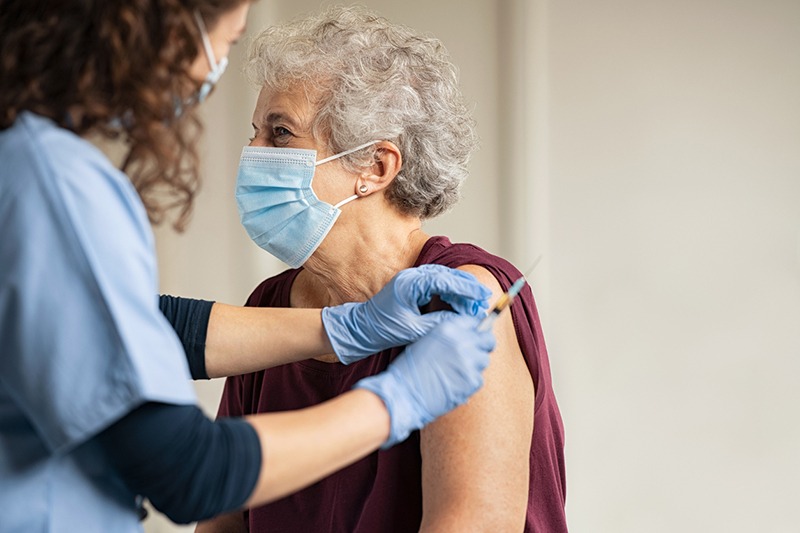 Picture of an elderly woman getting her vaccine shot.