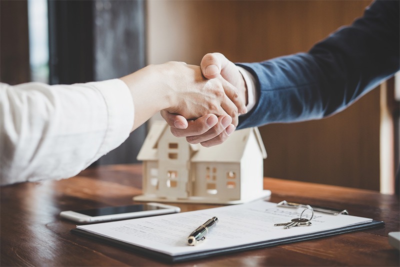  Real estate agent and buyer shaking hands