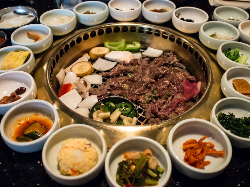 a Korean BBQ set up on the grill with side dishes