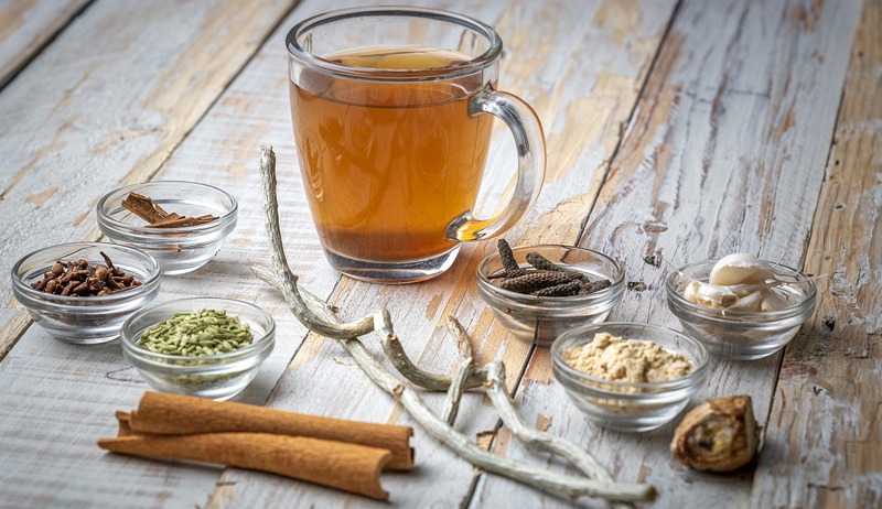 a cup of tea along with different herbs and spices