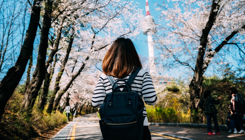 a young woman with a backpack traveling into N Seoul Tower at Namsan Mountain
