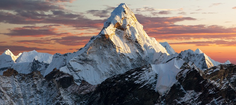 snow-covered Mt. Everest, sunset sky, clouds