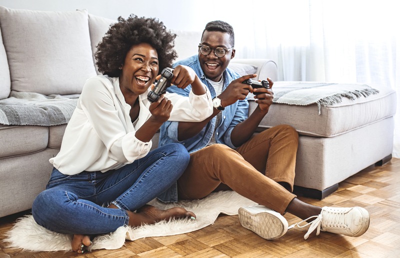 two people playing with a video game console at home