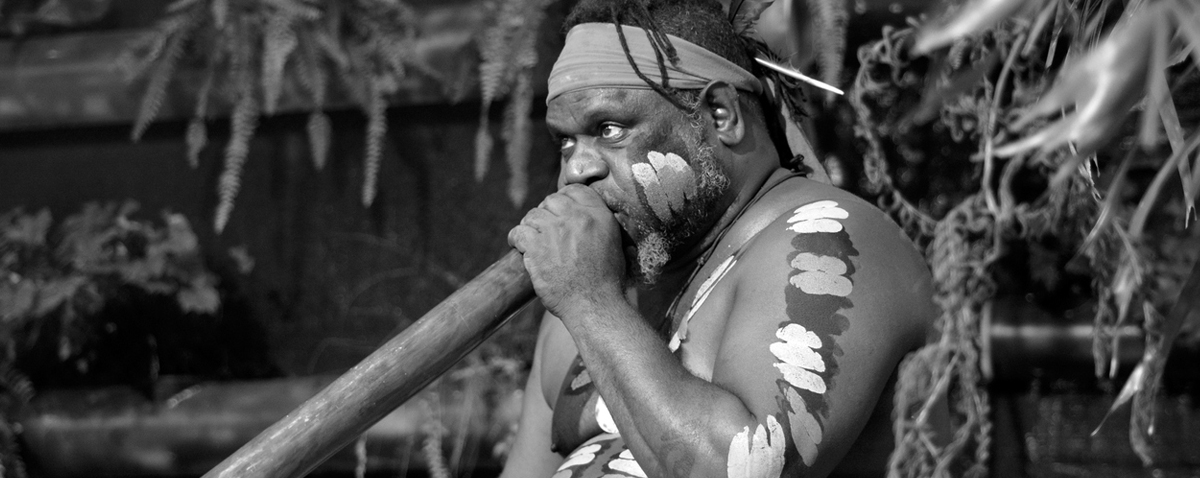 Aboriginal man playing music on didgeridoo
