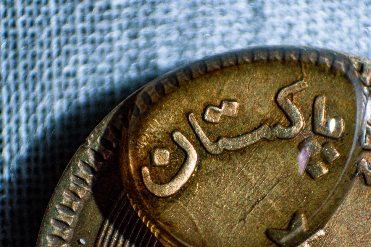 Macro shot of a Pakistani coin showing Pakistan written in urdu language