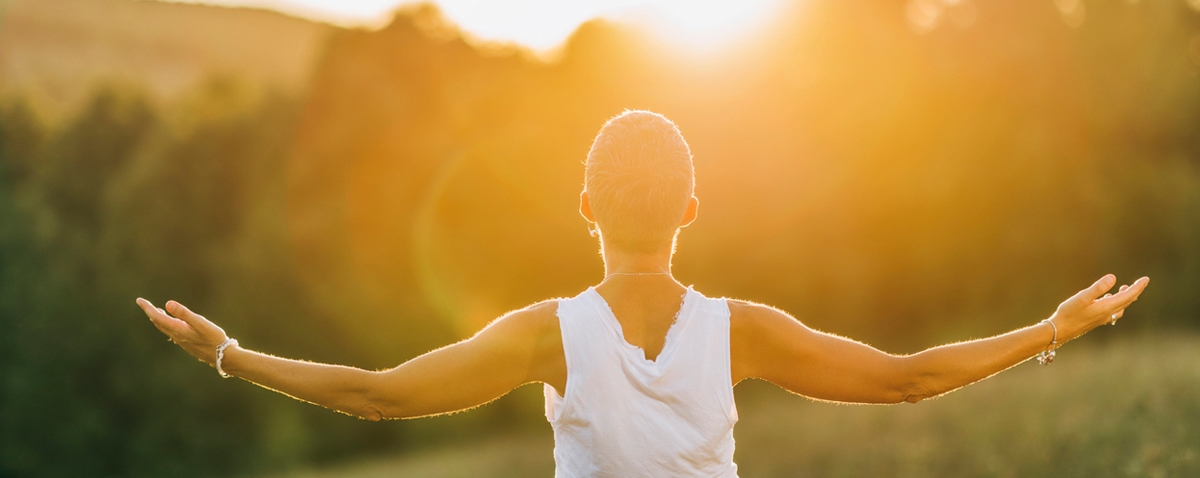 a person facing the sun with arms wide open