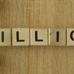 spelling the word “billion” using wooden letter blocks