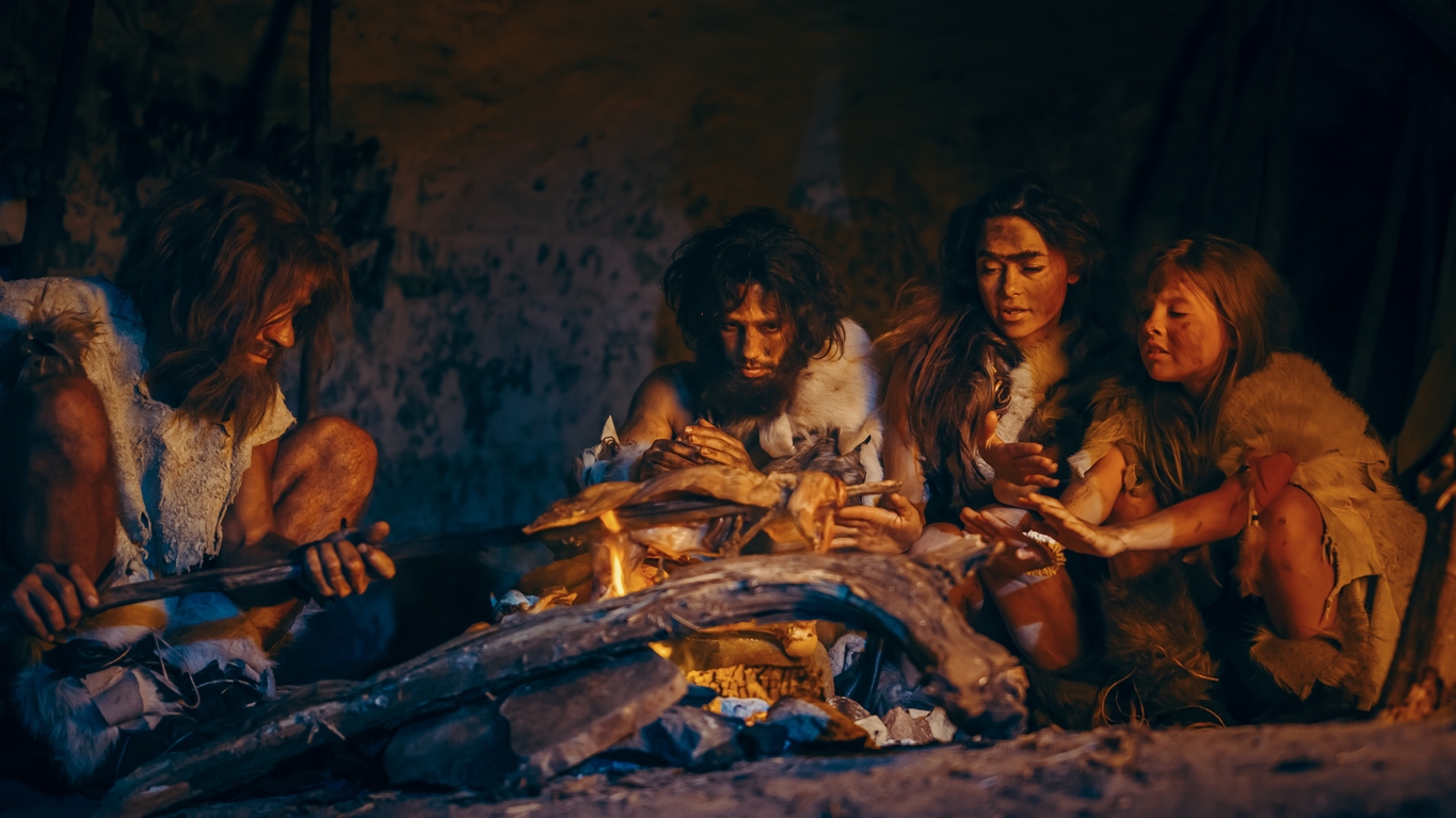 tribe of prehistoric hunter-gatherers grilling meat