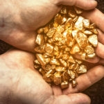 person holding gold nuggets