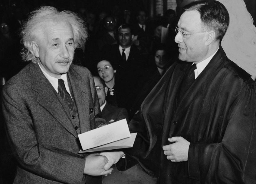 Albert Einstein shaking hands with a man
