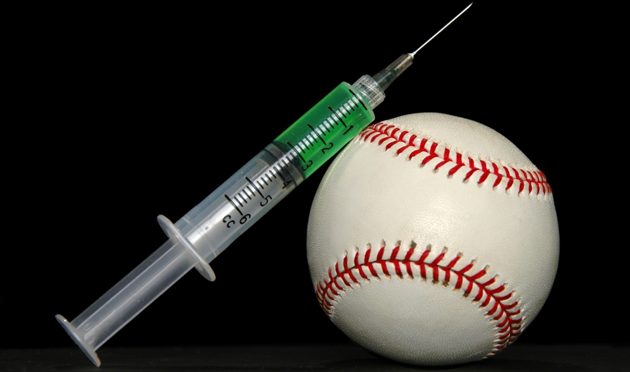a syringe of steroids leaning on a baseball