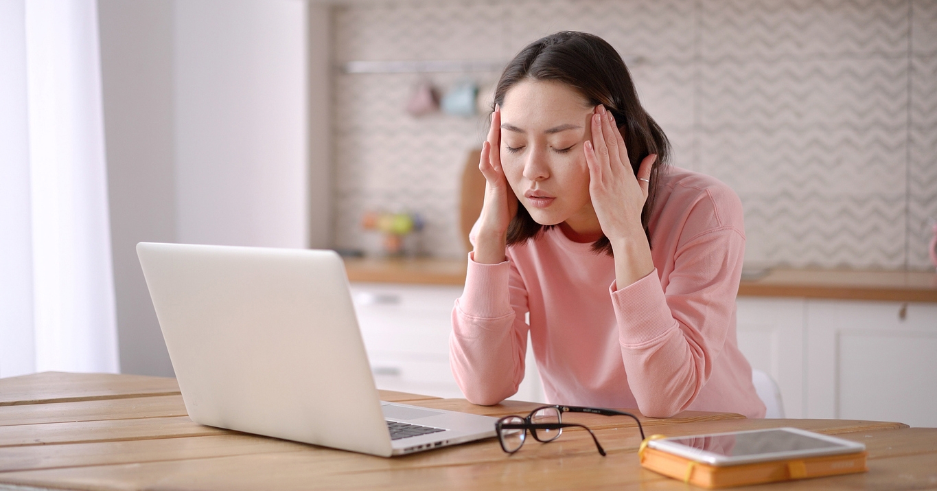 a woman in front of her laptop feeling stressed