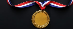 A gold medal on a red, white, and blue ribbon