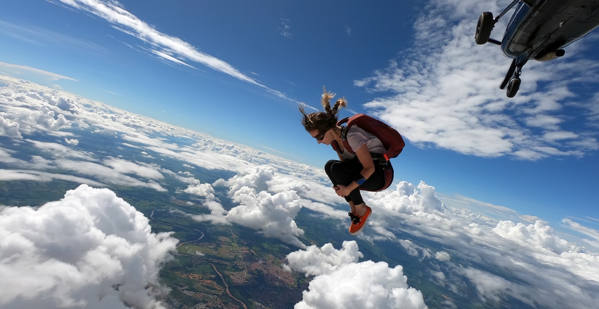 Young woman skydiver jumping from the plane