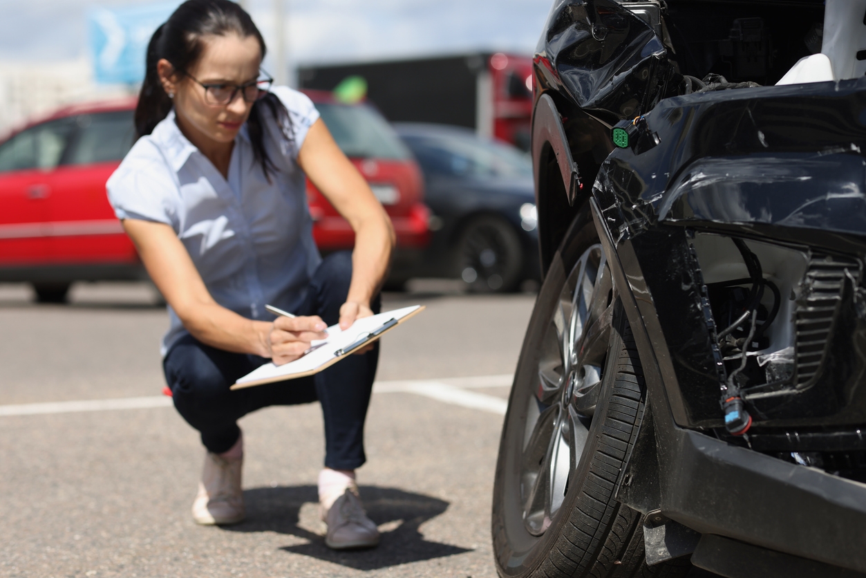 woman inspecting a car after a crash