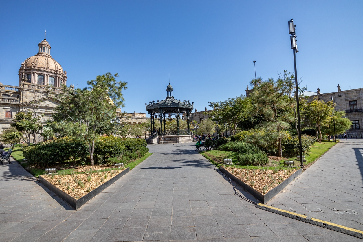 Panoramic view of the Plaza de Armas with a metal kiosk in background against blue sky