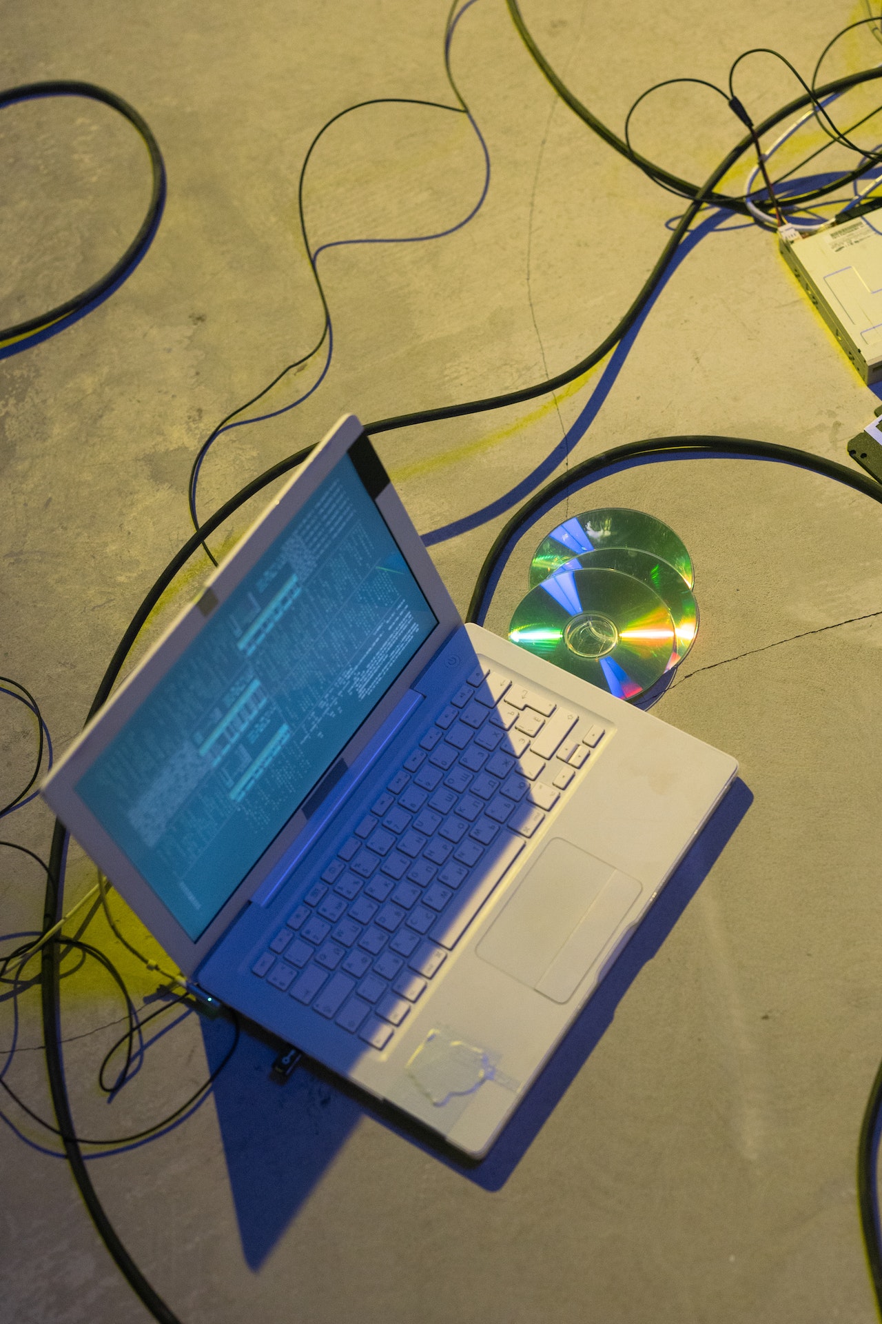 laptop near compact disc on the concrete ground