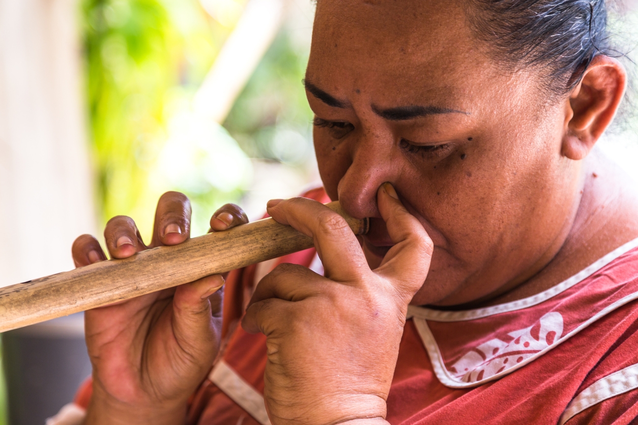 woman plays traditional nose flute