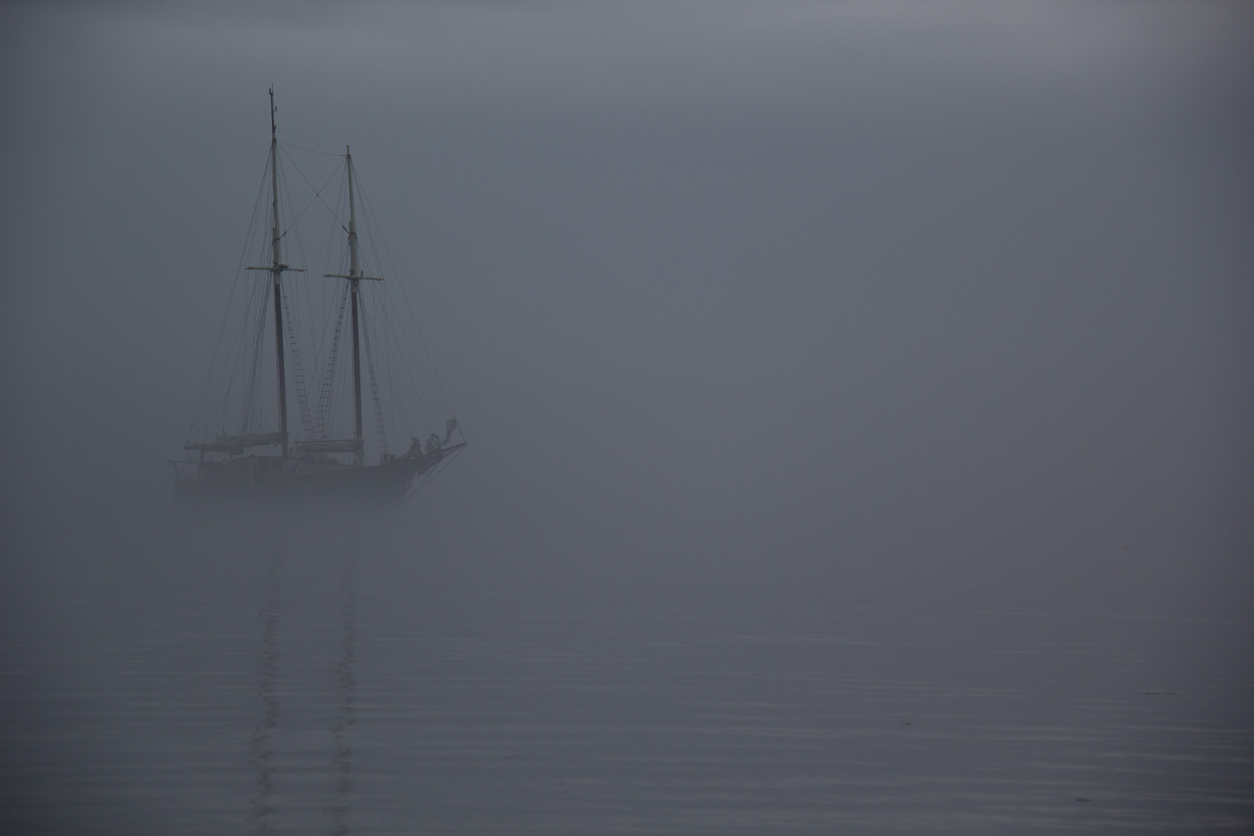 Ghostly ship sailing in fog