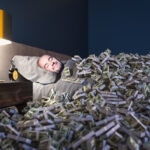 Man sleeping in a bed covered with money