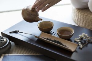 Person pouring tea in Chinese tea cups