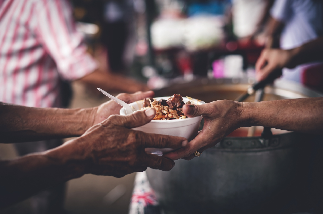 Volunteer handing out food at a community kitchen