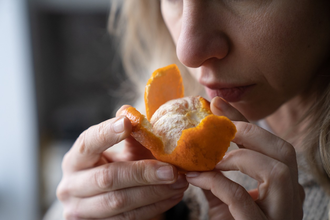 Woman smelling a fresh tangerine